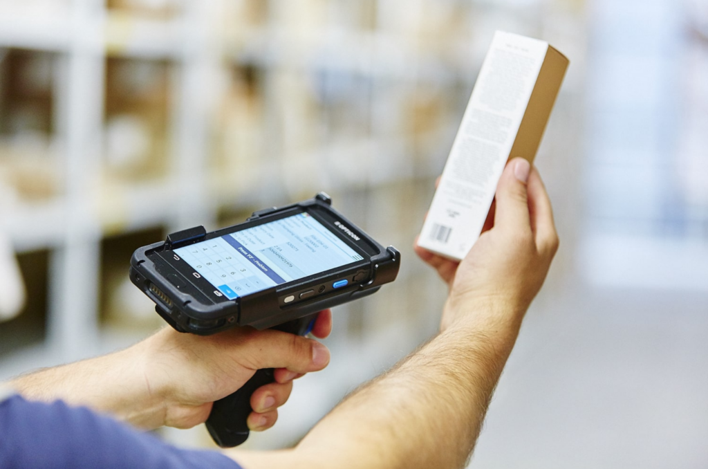 Person scanning a barcode of a white rectangular box